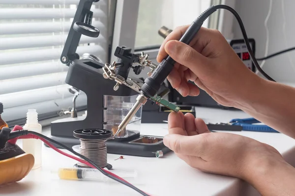 Bir lehim istasyonu ve diğer bileşenler kullanılarak lehimleme ile radyo panosunun onarımı