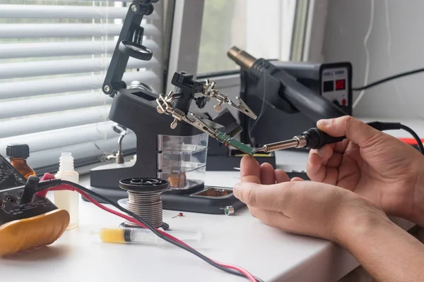 Bir lehim istasyonu ve diğer bileşenler kullanılarak lehimleme ile radyo panosunun onarımı