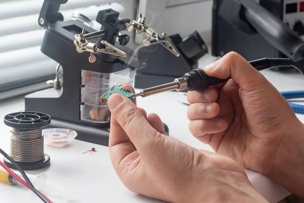 Bir lehim istasyonu ve diğer bileşenler kullanılarak lehimleme ile radyo panosunun onarımı