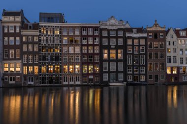 Amsterdam, alacakaranlıkta, kanalı'nın su sakin yansıtan windows ışıklarını ile binaların