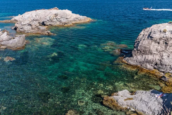 The crystal clear, aqua coloured waters off the coast of Cabo de Palos, in Murcia, Spain. It is summer and the day is sunny and hot.