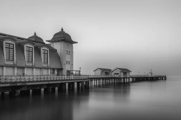The victorian architecture of Penarth Pier, near Cardiff on the coast of south Wales. The sea is smooth due to a long shutter speed. Black and white