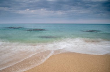 Akdeniz sahillerinde dalgalar, gün doğumunda.