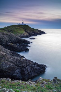 Strumble Baş Feneri, Pembrokeshire, gün batımında.