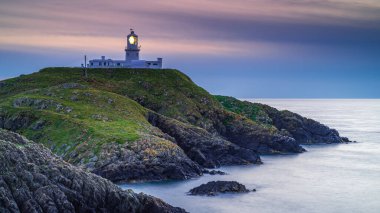 Strumble Baş Feneri, Pembrokeshire, gün batımında.