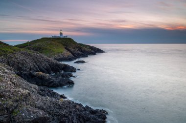 Strumble Baş Feneri, Pembrokeshire, gün batımında.