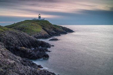 Strumble Baş Feneri, Pembrokeshire, gün batımında.