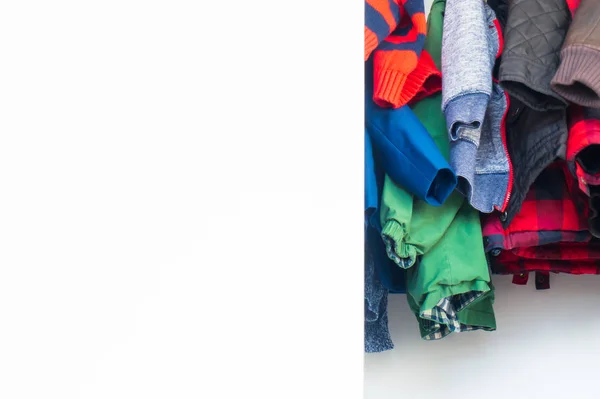 Parte inferior de los niños chaquetas y ropa de invierno colgando en un armario real con un montón de espacio en blanco para la copia, espacio para el texto . — Foto de Stock