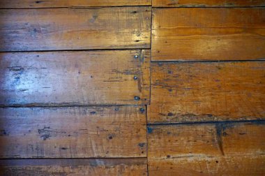 Eski ahşap zeminler, tırnakları gösteren, düzensiz bir desenle ayarlandı. Bazı pencere ışığı. Çizik ve scuffed.