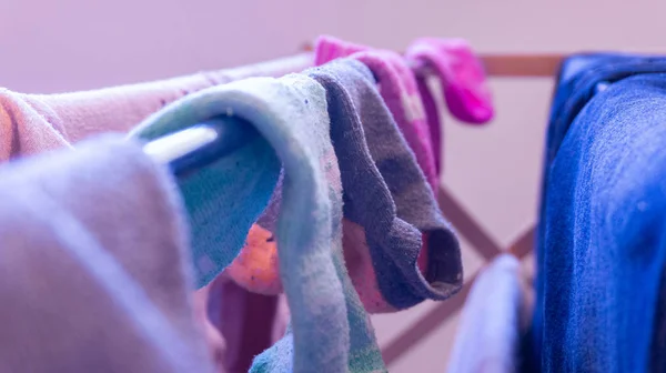 Meias incomparáveis secando em um rack, durante o dia. Representando dia de lavanderia, limpeza, tarefas domésticas e falta de pares de meias . — Fotografia de Stock