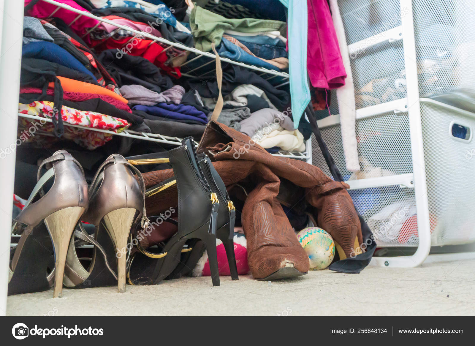 compact Actively batch Woman's closet with high heel shoes, stacked, folded clothes on shelves and  part of robes hanging. Depicting closet organization, time to donate  clothes, fashion lifestyle, consumerism, etc. Stock Photo by  ©thoughtsofjoyce 256848134