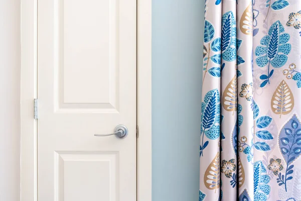 Home interior showing colonial closet door with blue curtain decor and light blue painted wall. — Stock Photo, Image