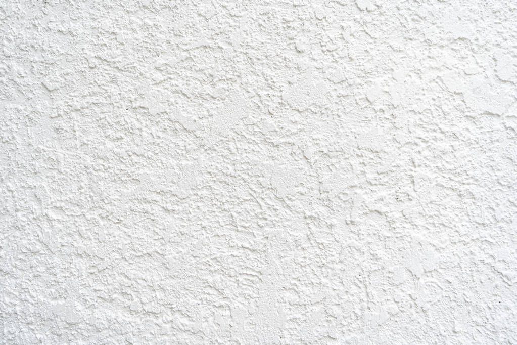 Exterior stucco white wall, useful as a background photo. Room for copy and text. The stucco material is textured and painted white.