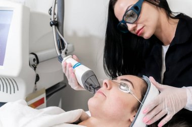 Güzellik lazer teknisyeni bir tıbbi spa ve güzellik kliniğinde cilt yenileme prosedürü gerçekleştiren. Kafkas kadın hasta.