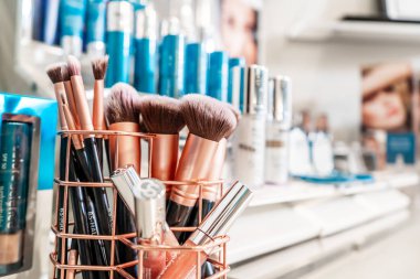 Bir makyaj tezgahında perakende ekranda Colorscience test ürünleri, kozmetik satan. Gümüş ve mavi markalı ambalaj.