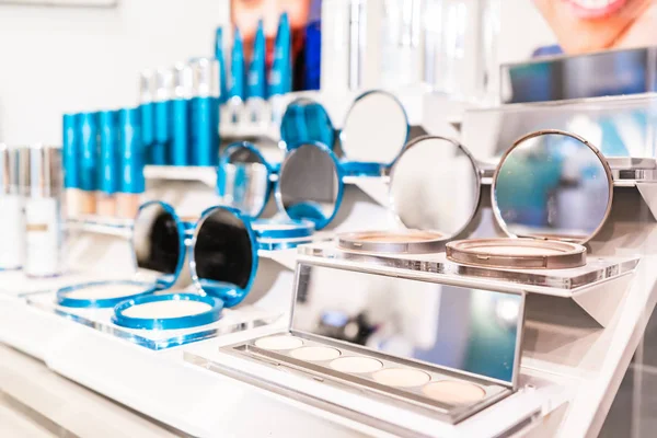 Colorscience tester products on retail display at a makeup counter store, selling the cosmetics. Silver and blue branded packaging.