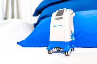 Minyatür Coolsculpting makine modeli bir medspa kliniğinde, yağ kaldırmak için cryolipolysis tedavisi için markalı bir odada bir hasta yatağında.