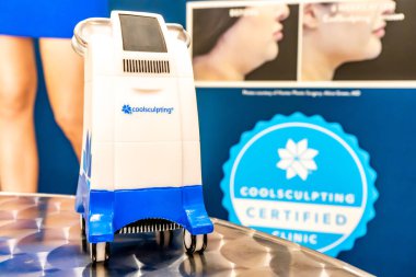 Minyatür Coolsculpting makine modeli bir medspa kliniğinde, yağ kaldırmak için cryolipolysis tedavisi için markalı bir odada bir hasta yatağında.