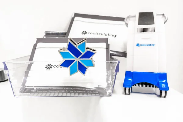 Minyatür Coolsculpting makine modeli, Coolsculpting logo pin ve paketler yanında, bir medspa içinde. Ameliyatsız cryolipolysis yağ alma tedavisi için kullanılan tedavi.
