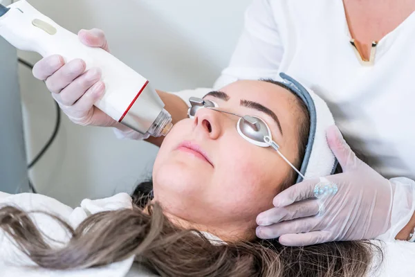 Estetista che applica il handpiece del microneedling di radiofrequenza alla faccia della donna per i trattamenti di serraggio della pelle ad una clinica di bellezza . — Foto Stock
