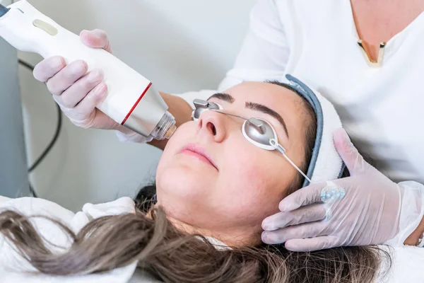 Güzellik kliniğinde cilt sıkılaştırma tedavileri için bir kadının yüzüne radyo frekansı microneedling handpiece uygulayarak Güzellik.