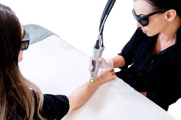 Séance d'épilation au laser avec technicienne beauté et patiente, épilation des poils du bras, dans une clinique de cosmétologie cutanée . — Photo
