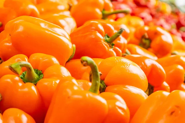 Sweet bell peppers (orange bell peppers), being  sold in a farmer\'s  market. Fresh, bright and shiny.