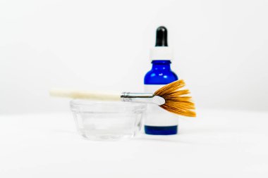 Kozmetik kimyasal peeling formülü için mavi boş göz damlası şişesi, tabak ve aplikatör makyaj fırçası, güzellik tedavileri için, beyaz boş etiketli. Metin için yer (kopyala).