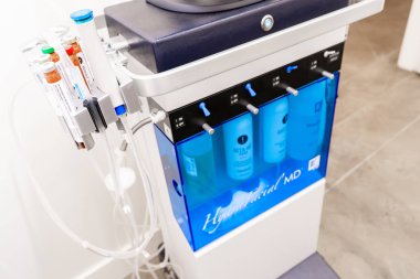 Surrey, Bc / Canada - 06 / 11 / 19: Yaşlanma ve akne tedavisi için bir güzellik merkezindeki Hydrafacial yüz tedavi makinesinin yanı. Şişelerde cilt güçlendirici seçenekleri gösterir.
