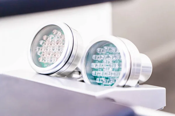 Kabzalarda cilt için iki tane Led light terapi, ampulleri gösteriyor. Yaşlanma önleyici ve cilt yumuşatma tedavisi için kırmızı ışık ve sivilce tedavisi için mavi ışık, cilt bakterilerini öldürmek için.