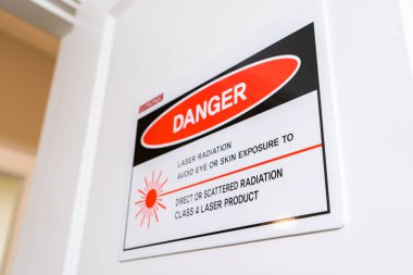 Surrey, BC, Kanada - 06 / 11 / 2019: Lazer radyasyon tehlike işareti hasta güvenliği için kozmetik lazer hizmetleri kullanılırken kapısında.