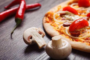 Yakın yukarı dilimlenmiş mantar, pizza barış dilimi, koyu ahşap arka planda kırmızı sıcak biber