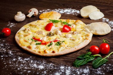 Yakın yukarı gülümseyen fare yüzü eritilmiş peynir, tavuk eti, kırmızı domates ve taze yeşil fesleğen ile çocuklar için Italyan pizza mantar, mozzarella ve kiraz ile süslenmiş kahverengi bir masada yaprakları. Emoji
