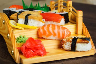 Kırmızı Sushi sashimi kahverengi ahşap masada ahşap bir köprü üzerinde ayarlayın. Melodi, karides, karidesli, zencefil, limon