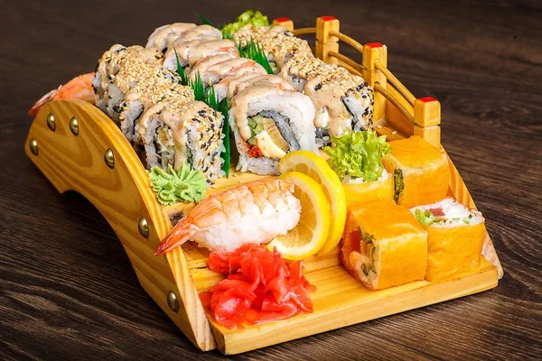 Vörös sushi sashimi szett, fából készült hídon, barna, fából készült asztalon. A dallam, garnéla, garnélarák, gyömbér, citrom — Stock Fotó