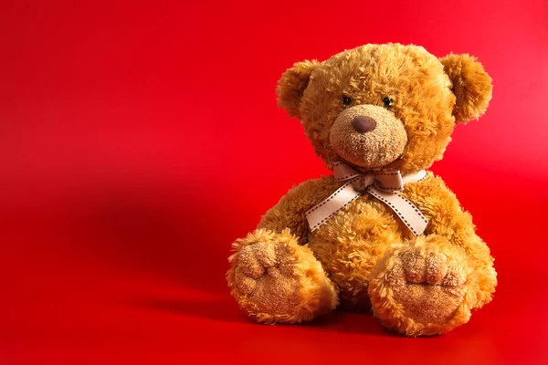 Soft warm cute brown teddy bear on color background. Isolated. Soft red background. Copy space for text. — Stock Photo, Image