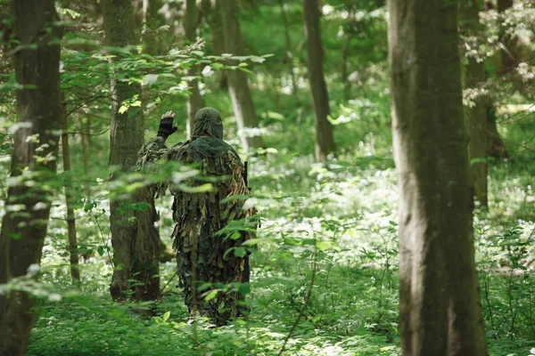 Un sniper camouflé en costume de ghillie dans la forêt. Il a tué un soldat. Règles Airsoft. Armée, passe temps, concept de jeu Images De Stock Libres De Droits