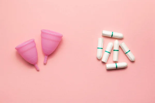 Dos copas menstruales de silicona reutilizables y tampones se comparan sobre un fondo rosa suave. Moderna mujer íntima alternativa de higiene ginecológica. Concepto de residuos Eco cero — Foto de Stock