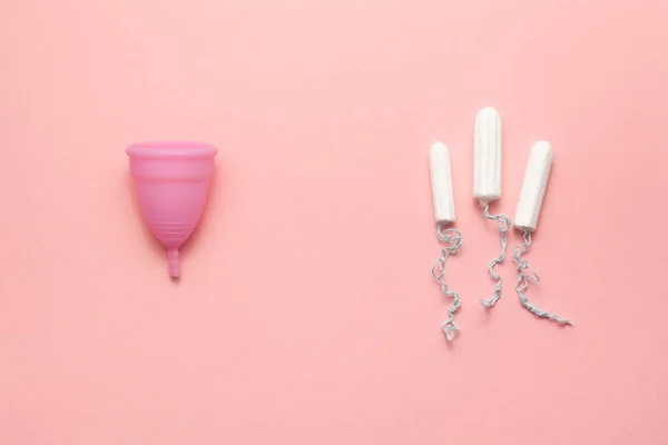 Återanvändbara silikon menstruations bägare och tamponger jämförelse på en mjuk rosa bakgrund. Modern kvinnlig intim alternativ gynekologisk hygien. Eco Zero avfall koncept — Stockfoto