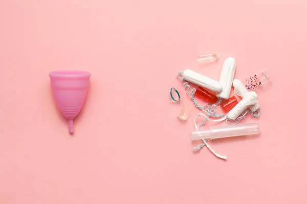 Coupe menstruelle en silicone réutilisable et tas de tampons comparaison de déchets sur un fond rose doux. Hygiène gynécologique alternative intime féminine moderne. Concept Eco zéro déchet — Photo