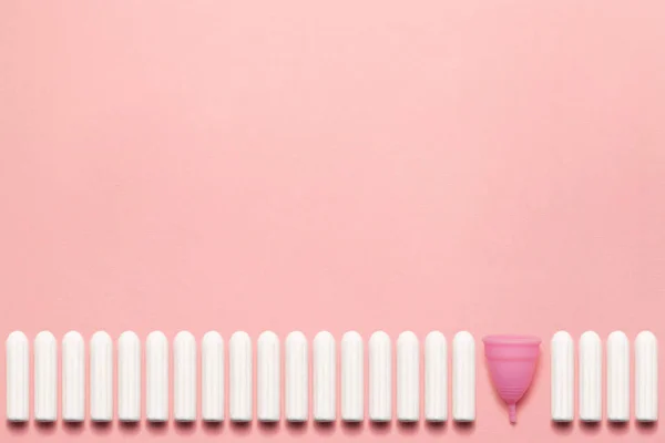 Återanvändbara silikon menstruations cupen och högen av tamponger jämförelse på en mjuk rosa bakgrund. Modern kvinnlig intim alternativ gynekologisk hygien. Eco Zero avfall koncept. Kopiera utrymmes plats för text — Stockfoto