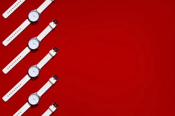 Reloj de silicona de diseño moderno blanco. Concepto de tiempo inteligente. Mosaico vista superior plano laico. Fondo de textura roja. Copiar espacio lugar para el texto — Foto de Stock