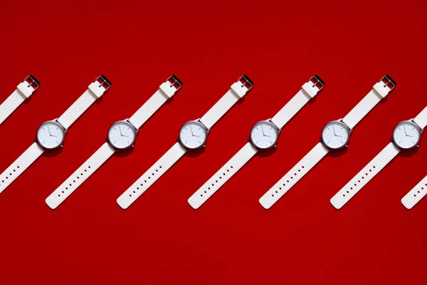 Reloj de silicona de diseño moderno blanco. Concepto de tiempo inteligente. Mosaico vista superior plano laico. Fondo de textura roja. Copiar espacio lugar para el texto — Foto de Stock