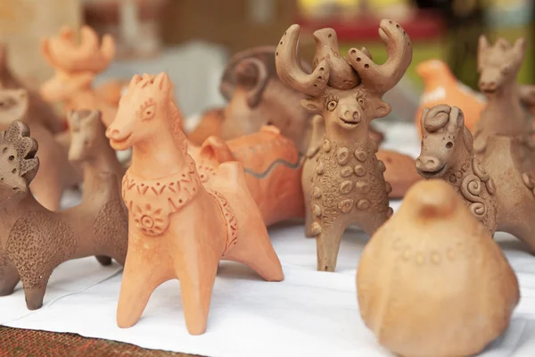 Ternopil, Ukraina, 24-07-2019. Selektivt fokus. Klassisk keramik lera keramik. Clay handgjorda figurer souvenirer, gåvor, amuletter. Katt, rådjur, häst, lejon, tjur, fåglar Stockfoto