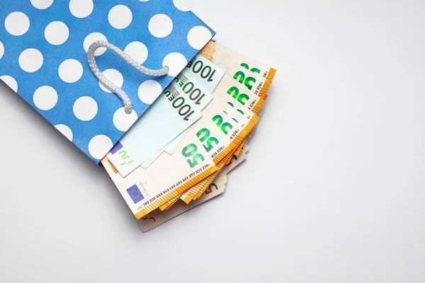 Billetes aislados de 100 y 50, ciento cincuenta euros están saliendo de una bolsa de papel azul sobre fondo blanco. Concepto de venta de compras. Copiar espacio lugar para el texto — Foto de Stock