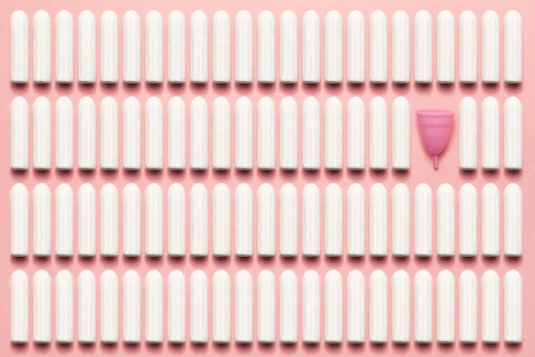 Yumuşak pembe arka planda yeniden kullanılabilir silikon menstrüel fincan ve tamponlar karşılaştırması. Modern kadın samimi alternatif jinekolojik hijyen. Eko sıfır atık kavramı — Stok fotoğraf