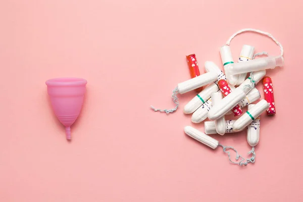 Copa menstrual de silicona reutilizable y montón de tampones comparación sobre un fondo rosa suave. Moderna mujer íntima alternativa de higiene ginecológica. Concepto de residuos Eco cero — Foto de Stock