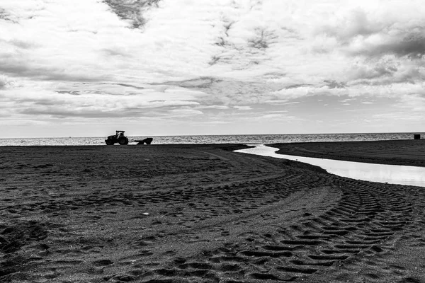 Vinterstrand med traktor, sand och bäck — Stockfoto