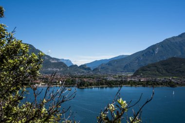 Mavi gökyüzü, yelkenli tekneler ve Trentino Alto Adige 'in yemyeşil dağları ile Ponale Yolu' ndan güzel Garda Gölü manzarası.