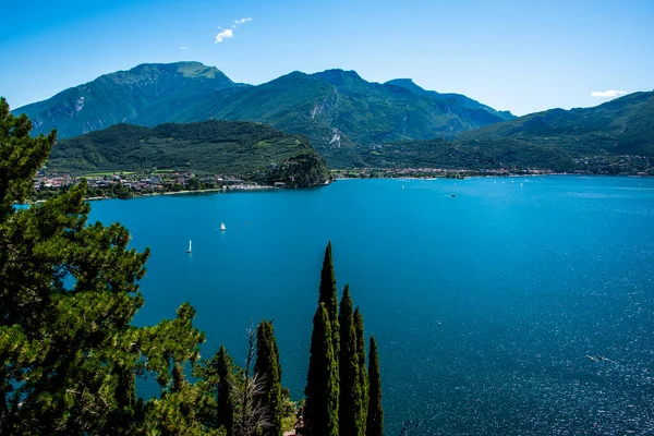 Mavi gökyüzü, yelkenli tekneler ve Trentino Alto Adige 'in yemyeşil dağları ile Ponale Yolu' ndan güzel Garda Gölü manzarası.